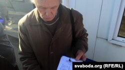 Мікола Чарнавус на рынку ў Баранавічах з подпісамі прадпрымальнікаў пад лістом да ўладаў