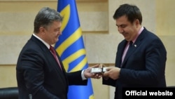 Президент Петро Порошенко (ліворуч) вручає посвідчення новому голові Одеської облдержадміністрації Міхеїлу Саакашвілі, 30 травня 2015 року