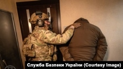 Дмитро Козюра та працівник СБУ під час затримання підозрюваного