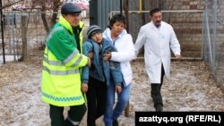 Врачи ведут мальчика после обморока. Село Березовка, 4 декабря 2014 года.
