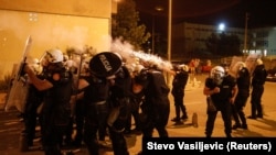 Riot police fire tear gas in front of a police station in Podgorica, Montenegro on June 24.