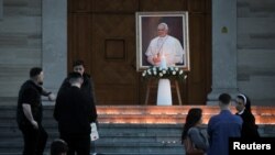 Приштинадагы чиркөөнүн алдында коюлган Рим папасы Францисктин сүрөтү. 