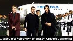 Прэзыдэнт Украіны Ўладзімір Зяленскі і яго жонка Алена па прыбыцьці ў Аб'яднаныя Арабскія Эміраты. Іх сустрэла міністарка міжнароднага супрацоўніцтва ААЭ Рым Аль Хашымі (справа), 16 лютага 2025 