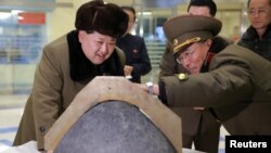 کیم جونگ‌اون در حال تماشای کلاهک یک موشک در پرتاب بازسازی‌شده یک موشک بالستیک