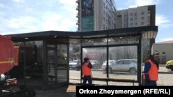 Рабочие моют остановку у здания цирка в Нур-Султане. 24 апреля 2021 года.