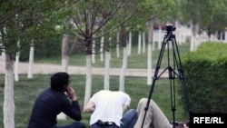 Телевизионные журналисты на траве. (Иллюстративное фото.)