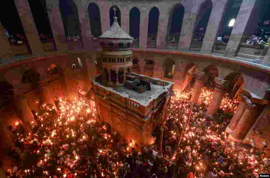 Люди собираются у Храма Гроба Господня во время церемонии схождения Благодатного огня, Иерусалим, 19 апреля 2025 года. REUTERS/Ammar Awad