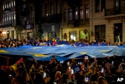 Imagine de duminică noapte, din București. Susținătorii lui Nicușor Dan sărbătoresc câștigarea alegerilor.