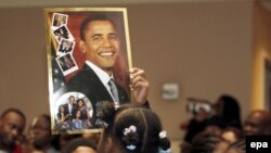 کودکان مدرسه‌ای در واشینگتن با عکسی از اوباما در هنگام مراسم تحلیف رئیس جمهوری جدید