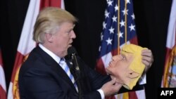 Trump öz maskasına baxır