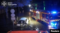 Рятувальники штовхають автомобіль через затоплену вулицю в Одесі. Фото ДСНС оприлюднене 1 жовтня