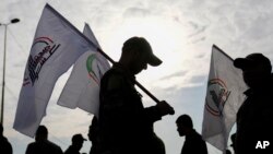 اعضای یک گروه شبه‌نظامی عراقی تحت حمایت ایران در مراسم تشییع جنازه نیروهایشان که در حملهٔ هوایی آمریکا کشته شدند