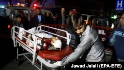 Afghan health workers bring an injured person to the hospital after a suicide attack targeted a wedding hall, in Kabul on November 20.